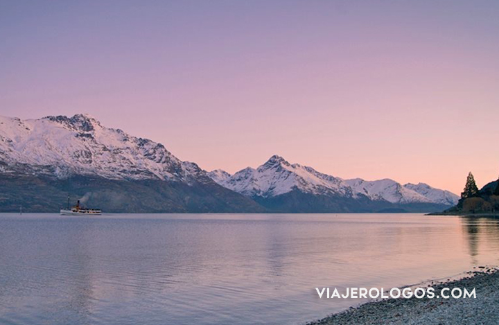 HORA DORADA EN EL LAGO DE QUEENSTOWN, NUEVA ZELANDA - BARCO Y MONTAÑAS NEVADAS AL FONDO