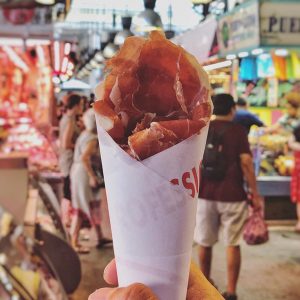Sosteniendo rollo de jamón en mercado de barcelona españa - comida del mundo