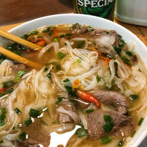 FOTOGRAFÍA DE PRODUCTO - Alimentos y bebidas del mundo - sopa pho soup - comida tradicional vietnamita en hanoi vietnam -caldo con flank carne cebollín y chile - palillos chinos